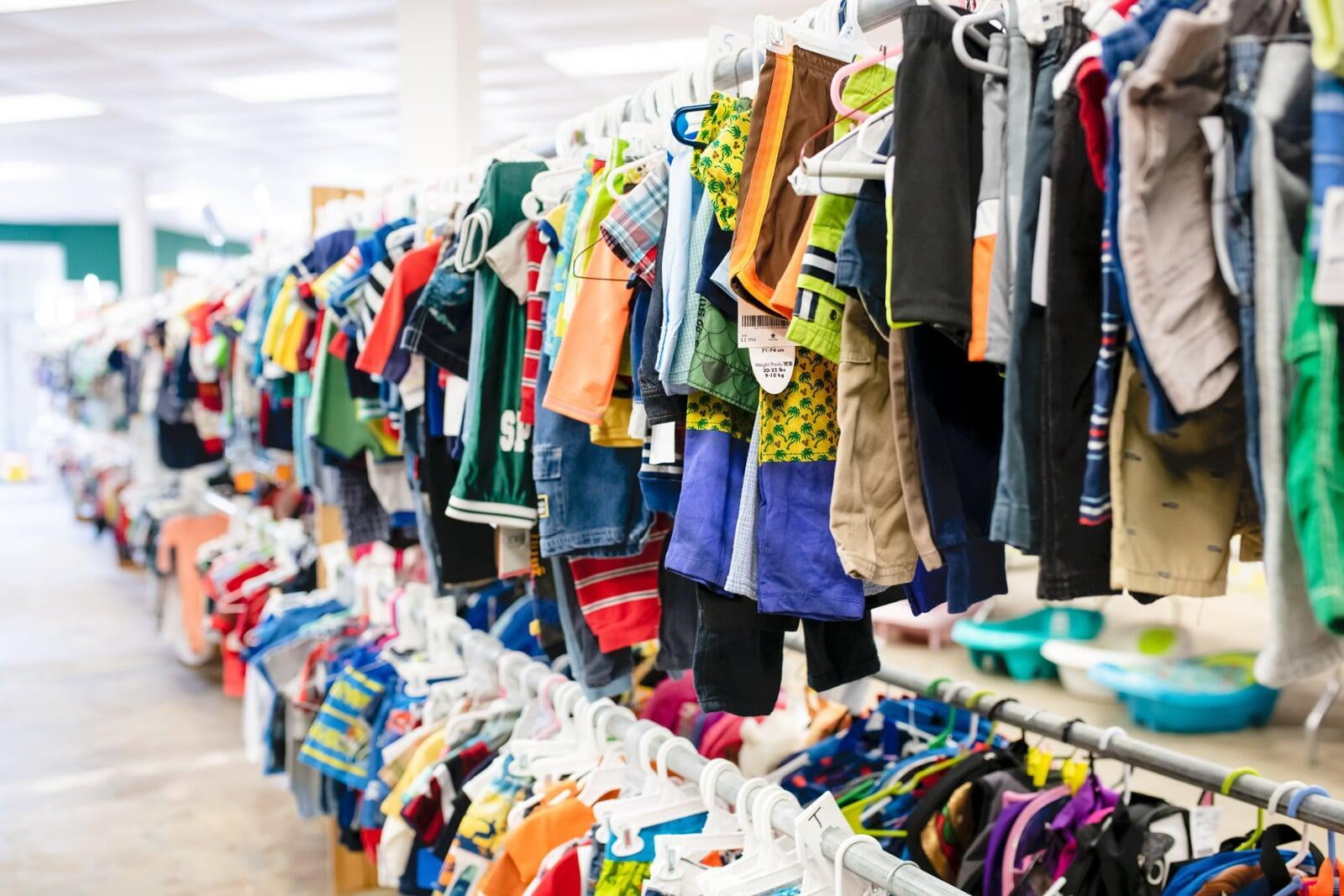 Mom and grandmother stand together, a few pieces of clothing in grandmom's hands, as they shop together for their family.